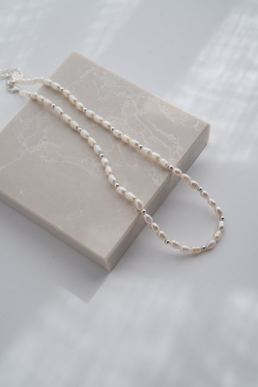 Pearl necklace on a beige box with a soft white background