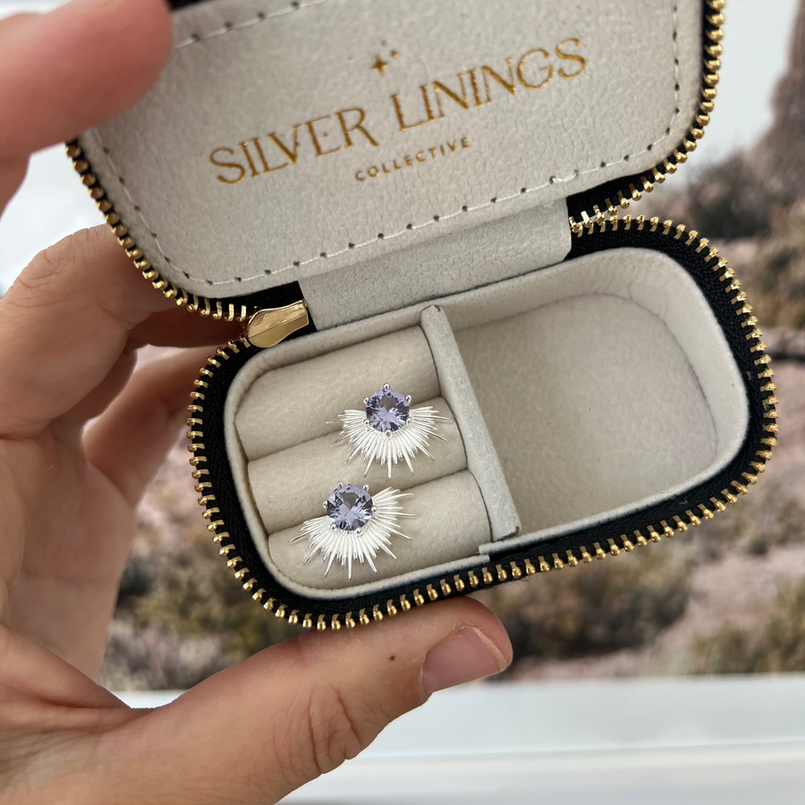 Jewelry case with 'Silver Linings' branding containing a pair of earrings.